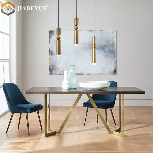 Modern dining table with dark wood top and gold-toned geometric metal legs paired with decorbites golden led chandelier