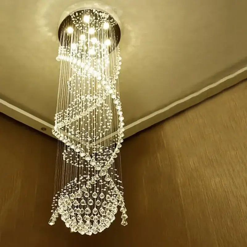 A modern double spiral crystal chandelier with clear faceted beads and metallic strands for hotel villa staircase lighting