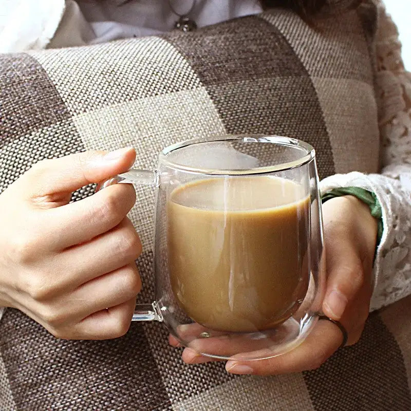 Modern double walled glass coffee mug by decorbites filled with coffee featuring a clear handle and sleek design