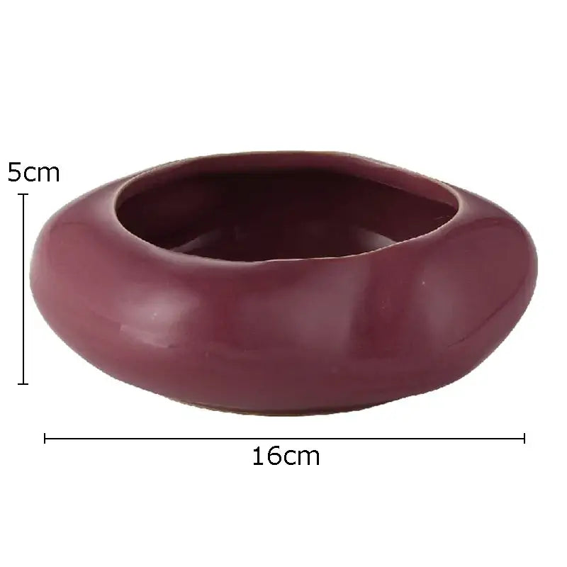 A smooth glossy maroon lotus seedpod ceramic incense burner with rounded organic shape and irregular edges for living room decor