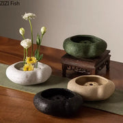 A collection of four modern earthy lotus seedpod ceramic incense burners with smooth perforated bowls in natural tones