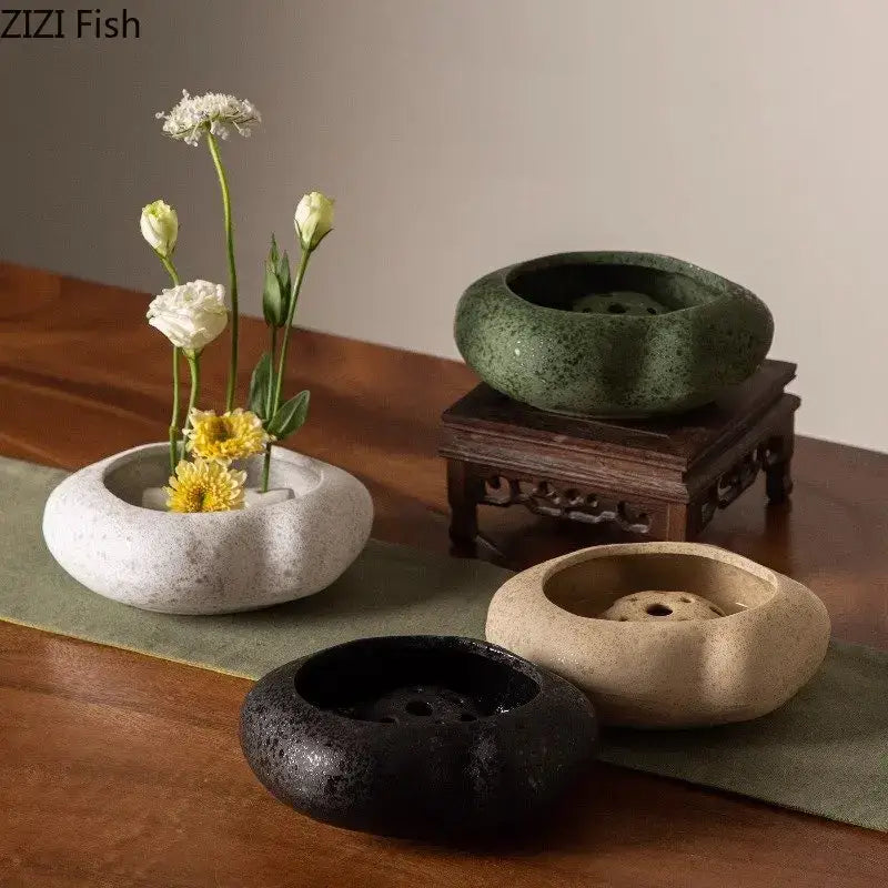 A collection of four modern earthy lotus seedpod ceramic incense burners with smooth perforated bowls in natural tones