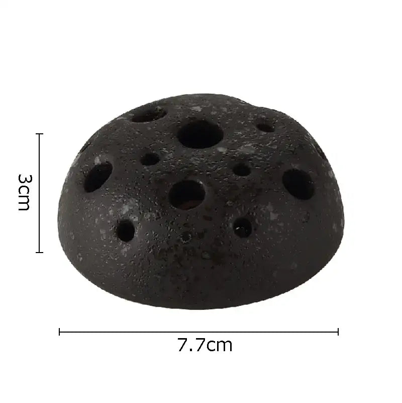 Black porous lotus seedpod ceramic incense burner with circular holes and rough texture for earthy living room decor