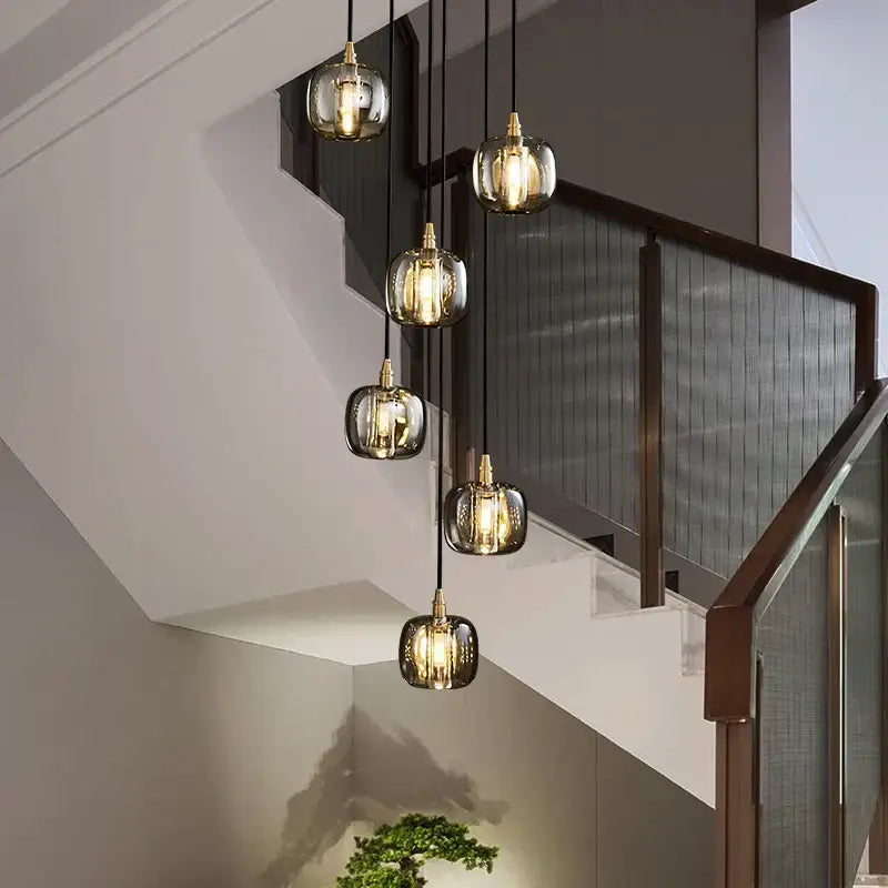 Five modern glass pendant lights with gold fixtures feature warm glow in decorbites elegant rotating staircase pendant light