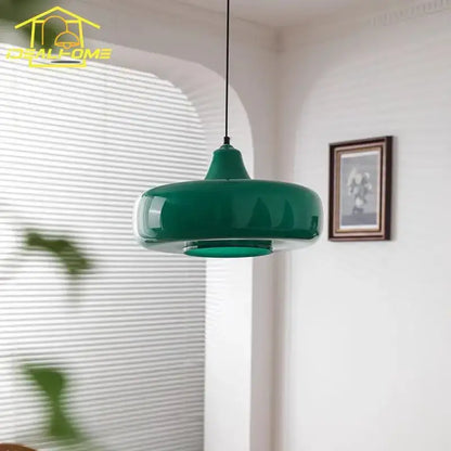 A sleek glossy emerald green glass pendant light with a modern rounded design for dining room use