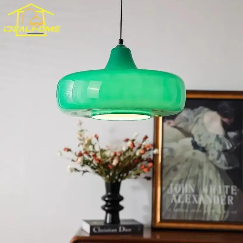 Modern emerald green glass pendant light with a sleek rounded design for dining room use featuring led lighting