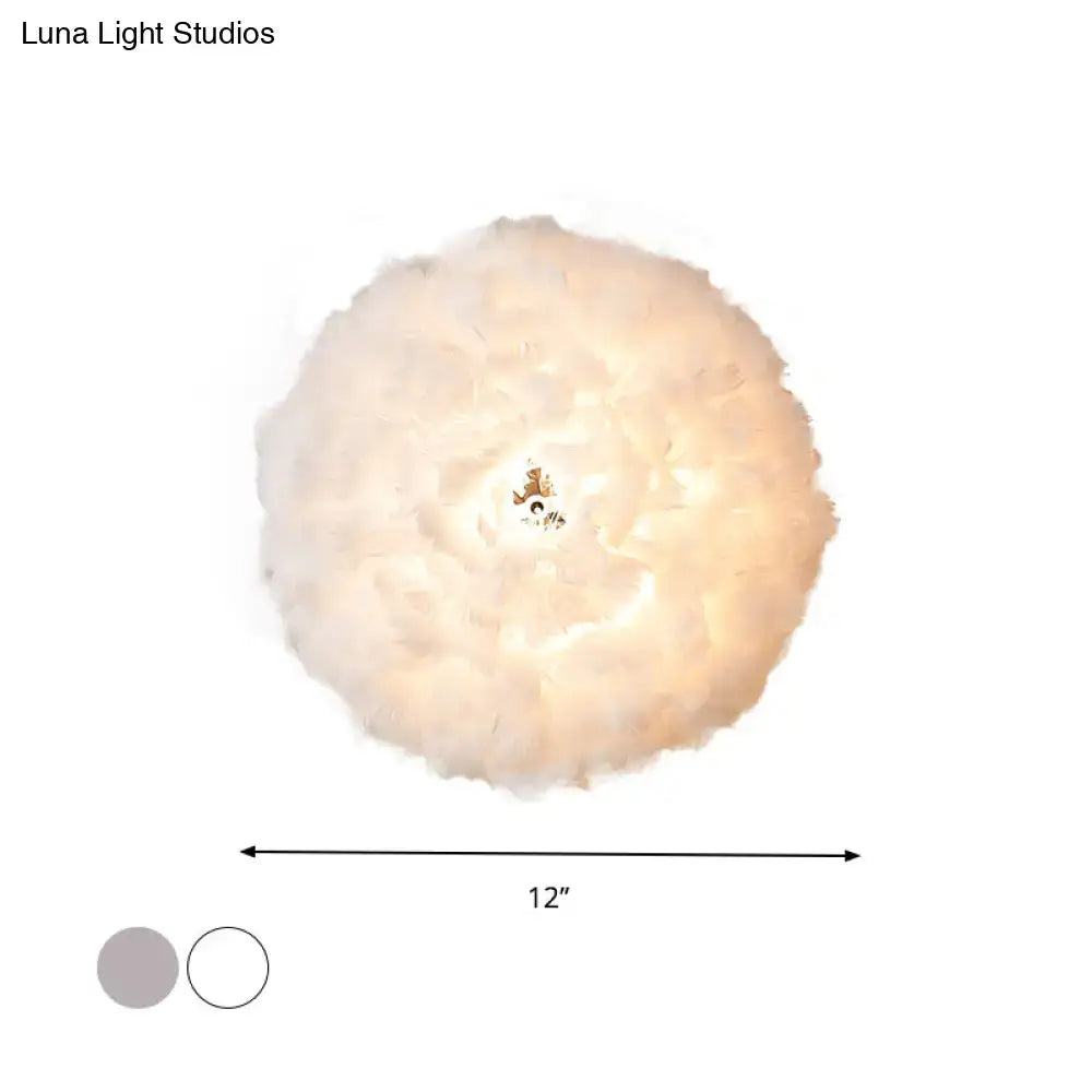 Modern feather material wall light in grey and white with a soft fluffy feather pendant and warm glow for bedroom use