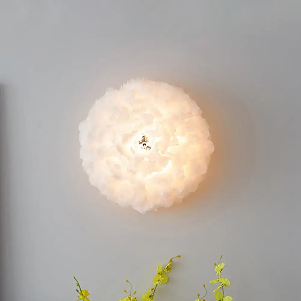 Modern feather material wall light in grey and white with a soft glowing cloud-shaped bedroom sconce design