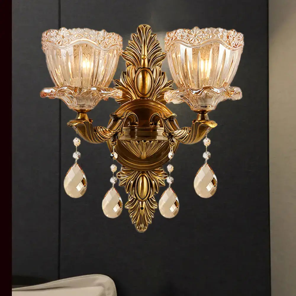 Modern floral brass wall sconce with gold tone, teardrop crystal drop, and fluted amber glass shades for living room