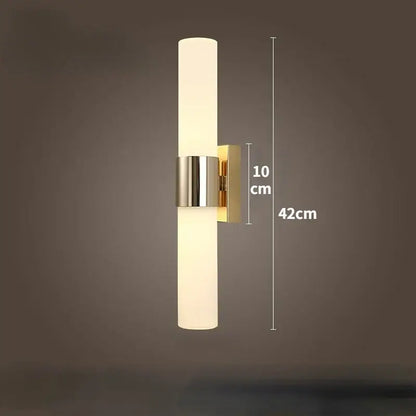 Modern gold-toned led wall lamp with frosted glass cylinder and polished metal accents for bedroom use
