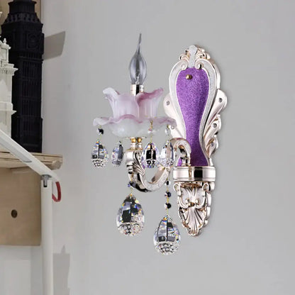 Modern frosted glass purple wall sconce featuring teardrop crystal pendants and pink glass flower accent for bedroom use