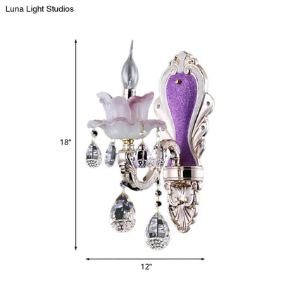 Elegant frosted glass purple wall sconce with teardrop crystal pendants and ornate floral metalwork for bedroom use