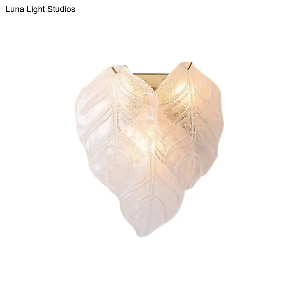 Modern frosted white glass leaf wall sconce light with heart-shaped translucent leaves and warm golden backlight