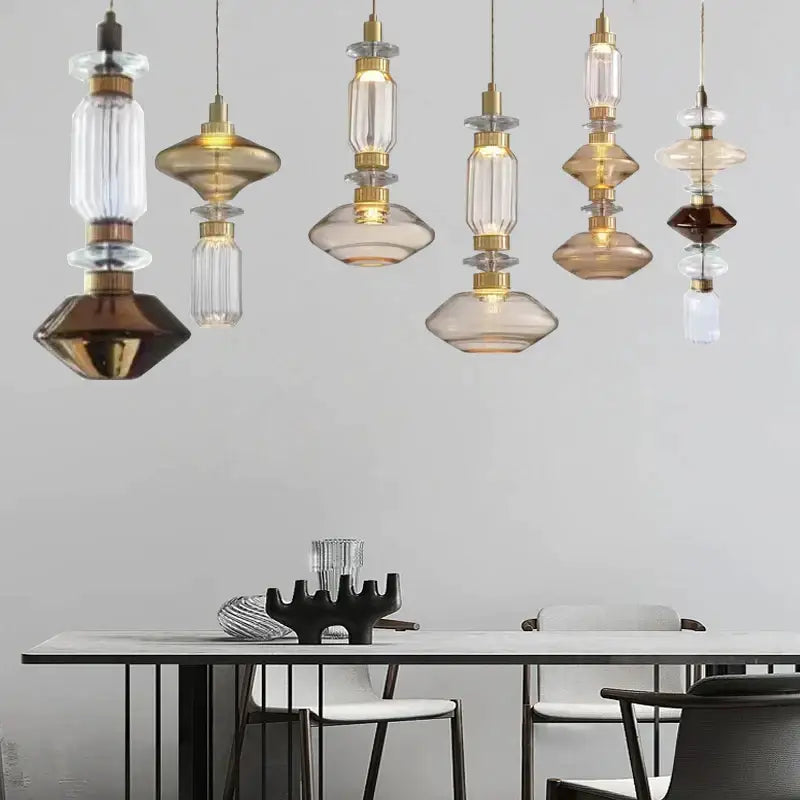 Modern geometric amber and clear glass chandelier with brass accents hanging above a dining table decorbites glass chandelier