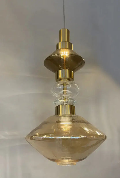 A modern pendant light with a gold-toned metal frame and amber-tinted glass shades decorbites glass chandelier