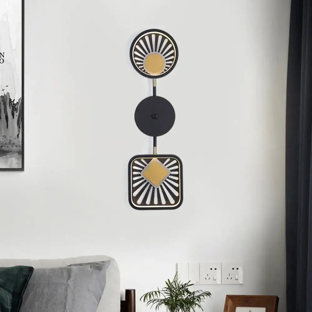 Modern geometric black and gold wall lamp with stacked circular and square shapes ideal for living room lighting