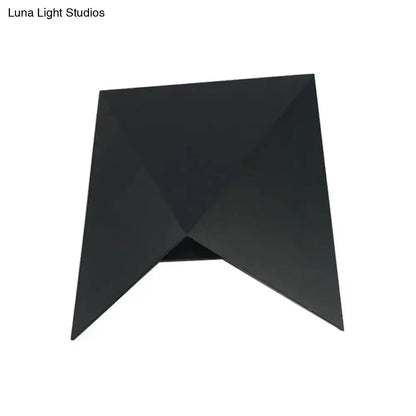 Modern geometric black metal wall sconce with angular faceted design ideal as bedroom wall lamp or metal wall sconce