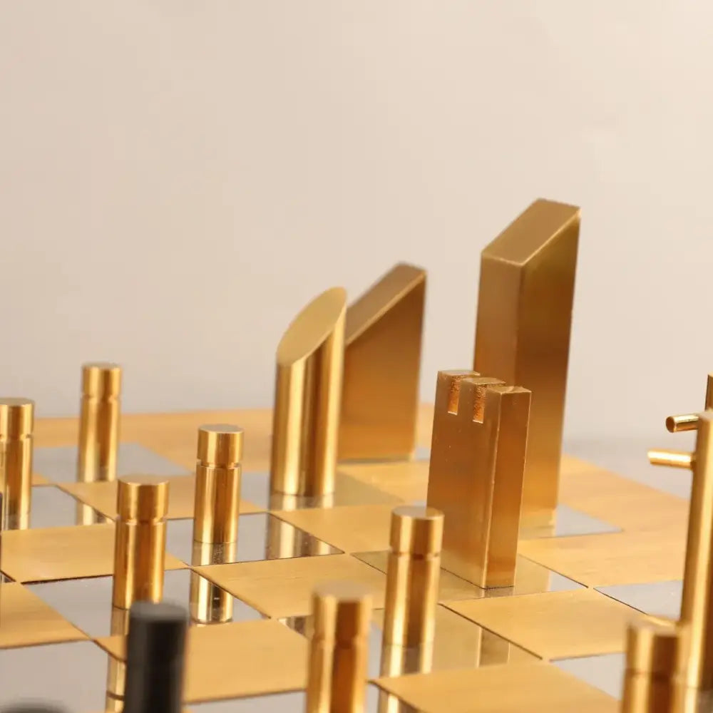 Modern geometric block chess set with golden brass pieces and mirrored board ideal for gold and black living room decor