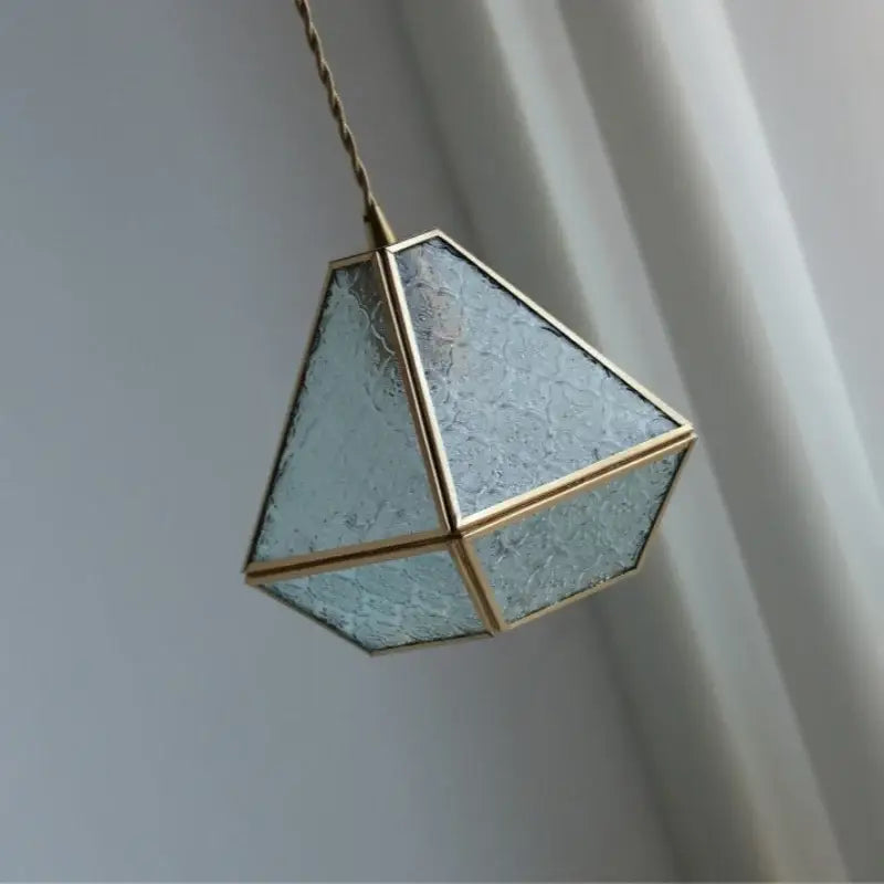 Modern geometric pendant light with textured decorbites blue glass panels and brass metal edges for dining room decor