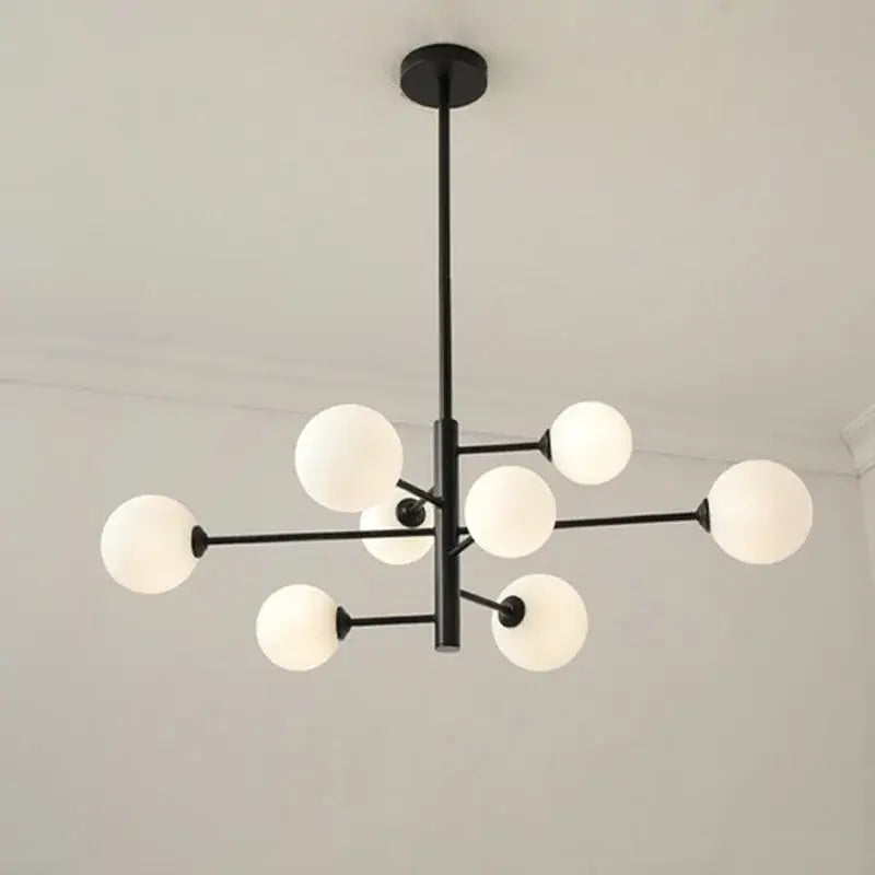 Modern geometric decorbites brass chandelier featuring black metal frame with frosted white glass globes for living room decor