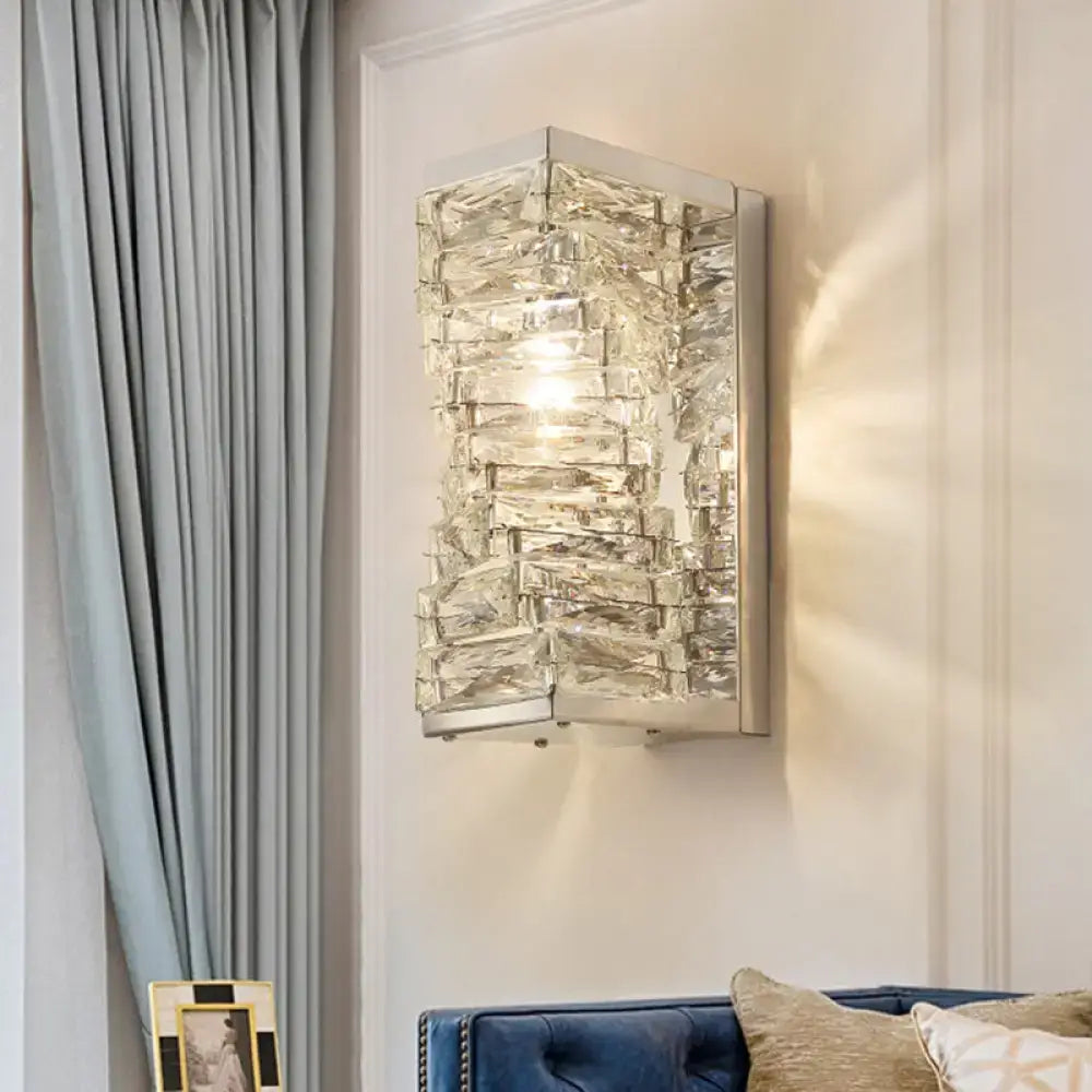 A modern geometric clear crystal wall sconce with stacked faceted pieces designed for living room lighting