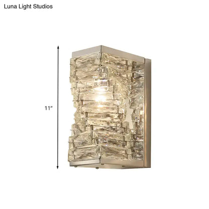 A modern geometric clear crystal wall sconce with stacked rectangular pieces in brushed nickel for living room lighting