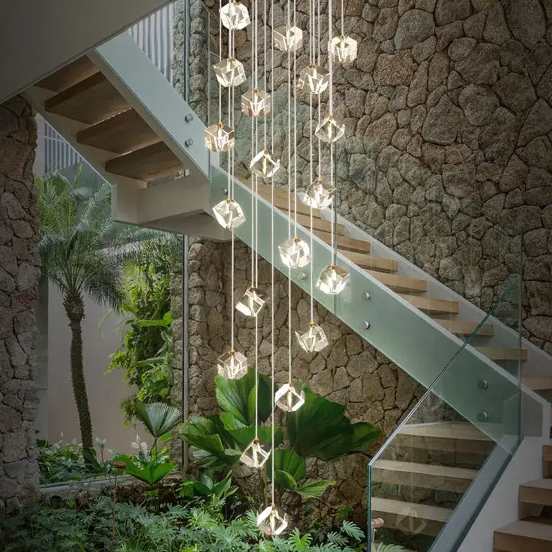 A modern geometric decorbites crystal led chandelier with faceted crystal pendants and gold-toned fixtures for staircases
