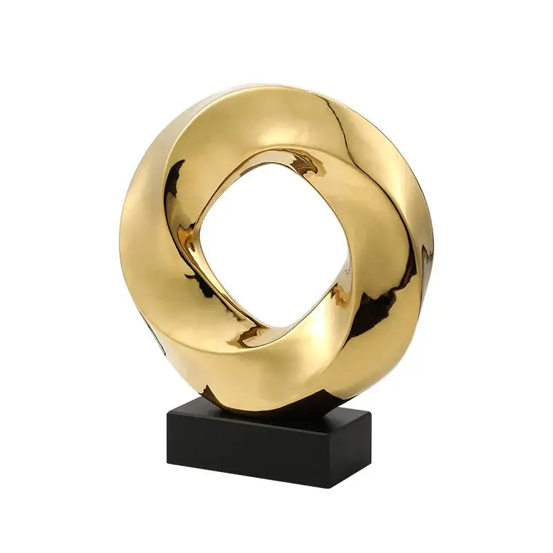 Modern geometric gold ring hollow sculpture with a twisted ring design on black base for living room decor