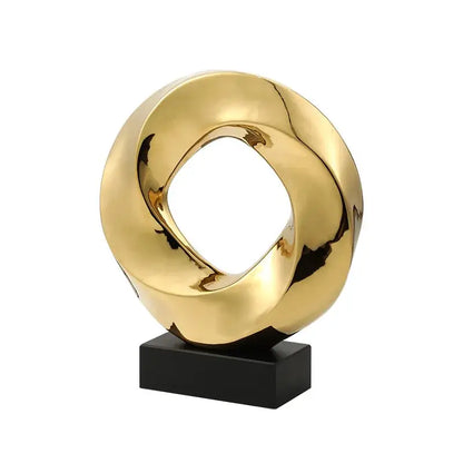 Modern geometric gold ring hollow sculpture with a twisted ring design on black base for living room decor