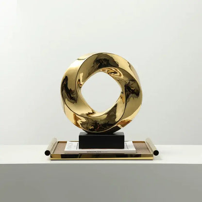 Shiny gold metallic abstract geometric gold ring hollow sculpture with twisted interlocking rings for living room decor