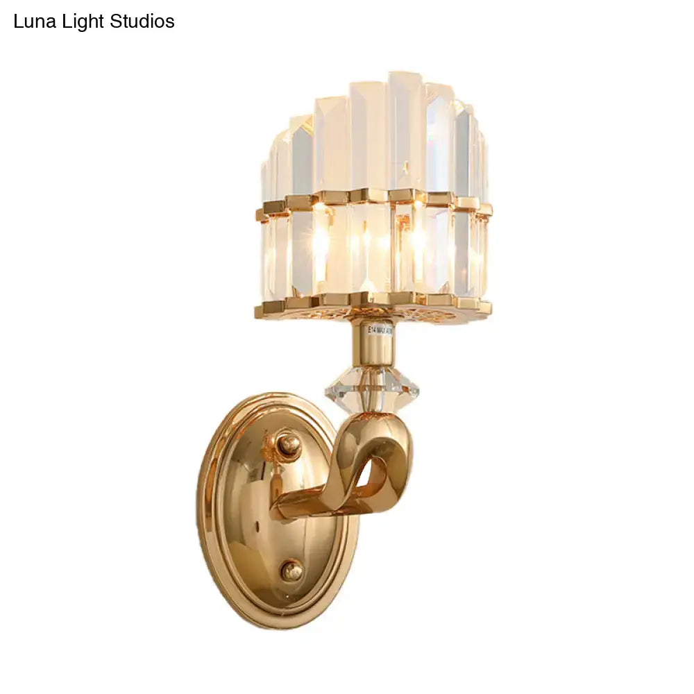 Gold-finished modern geometric wall lamp with tiered crystal shade and decorative curved arm for living room use