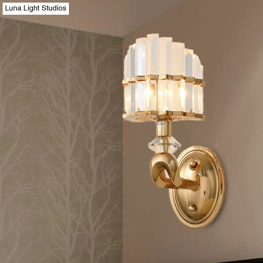 Modern geometric gold wall lamp featuring a tiered arrangement of clear faceted crystal panels and central decorative accent