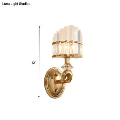 Modern geometric gold wall lamp with clear faceted crystal prisms and a decorative curved arm for living room use