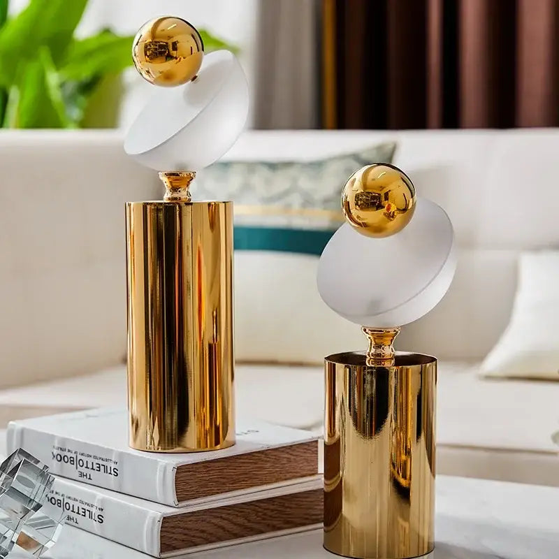 Modern geometric golden ball frosted glass sculpture with a golden cylindrical base for living room decor