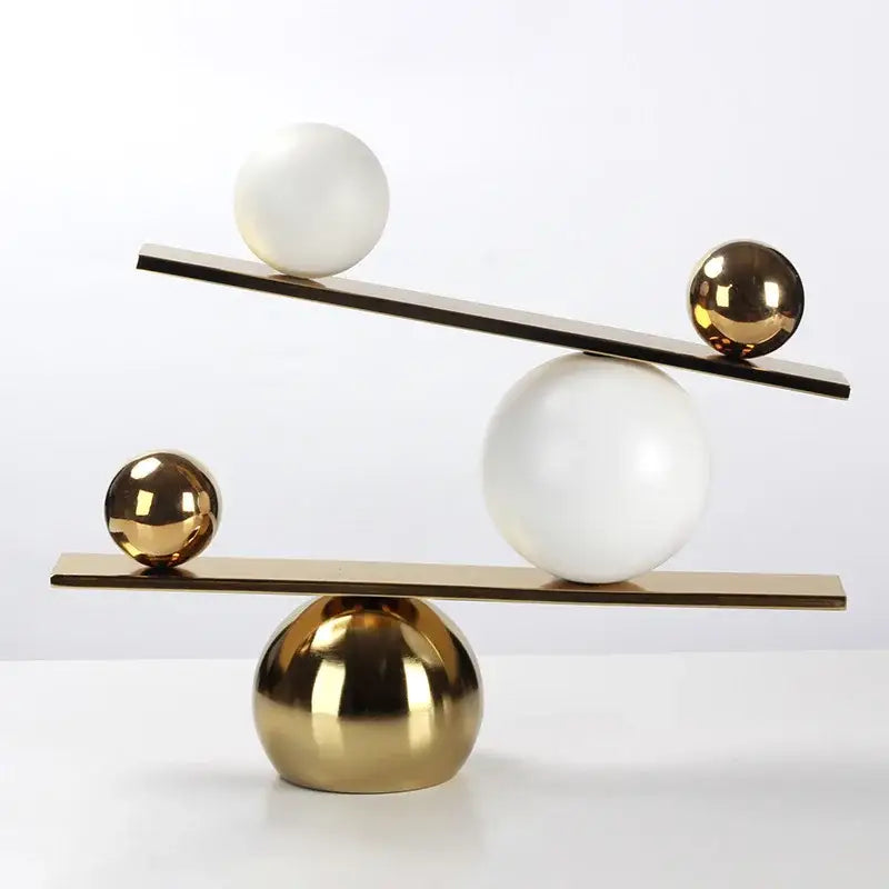 Modern geometric golden ball seesaw ramp living room sculpture featuring polished gold and matte white spheres on metallic planks