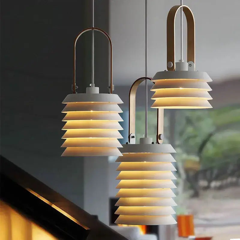 Modern geometric iron table lamp with white tiered pendant lights and brass handles for elegant living room decorbites