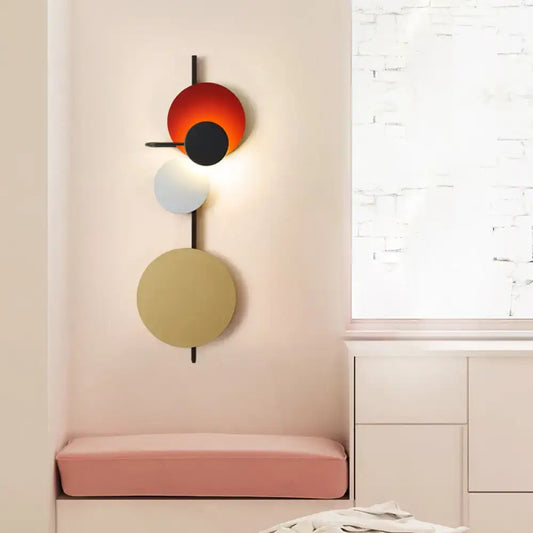 Modern geometric led wall light living room sconce with stacked orange black white beige discs on black rod in red pink blue tones