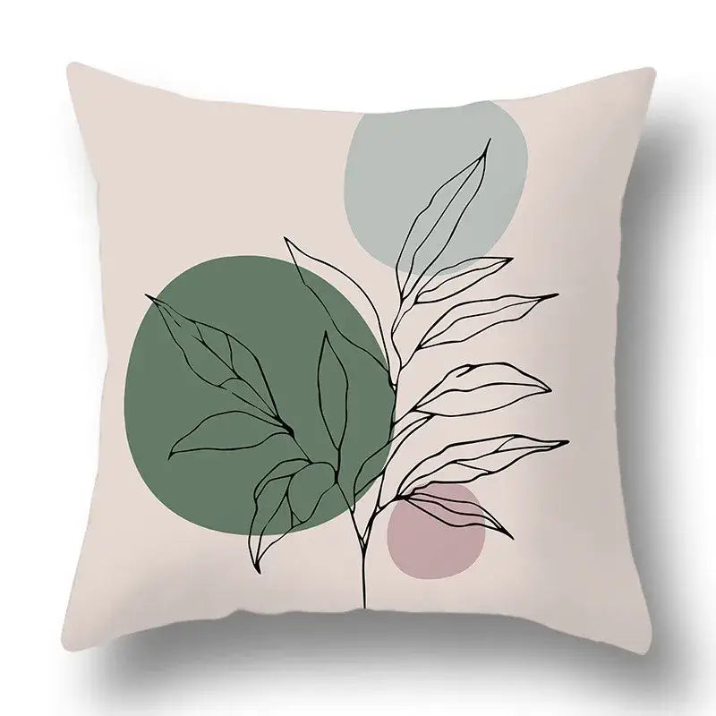 Beige pillow cover with geometric print featuring black line-drawn green plants on soft green gray and dusty rose backgrounds