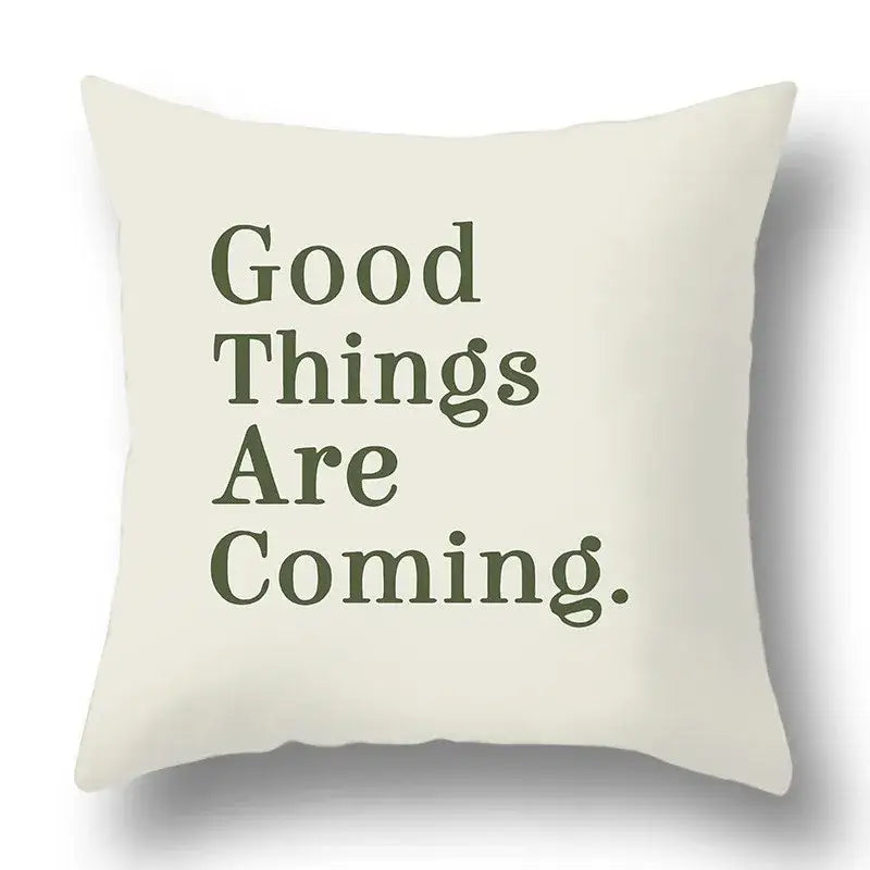 Cream-colored pillow cover with good things are coming in dark olive serif font decorbites green plants geometric print