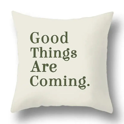 Cream-colored pillow cover with good things are coming in dark olive serif font decorbites green plants geometric print