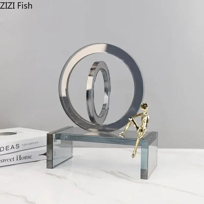 Shiny chrome and gold abstract geometric ring chair statue with interlocking rings and miniature figure on ring chair base