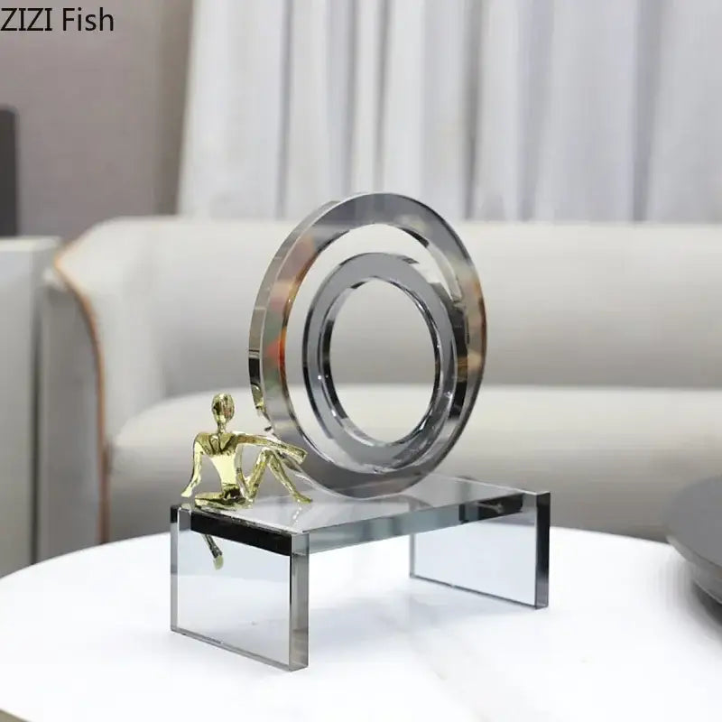 A modern geometric ring chair sculpture with polished chrome ring and gold figurine on a transparent ring chair base