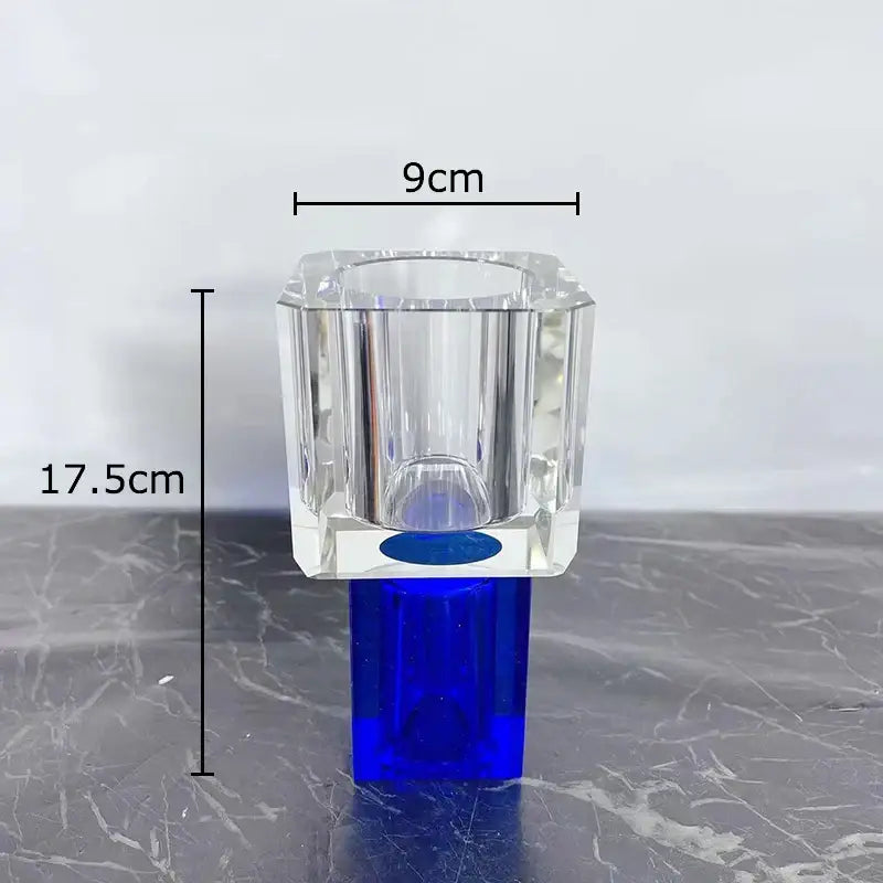 Clear crystal vase with blue base and faceted design holding decorbites geometric square artificial flowers decor