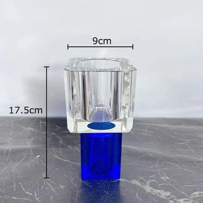 Clear crystal vase with blue base and faceted design holding decorbites geometric square artificial flowers decor