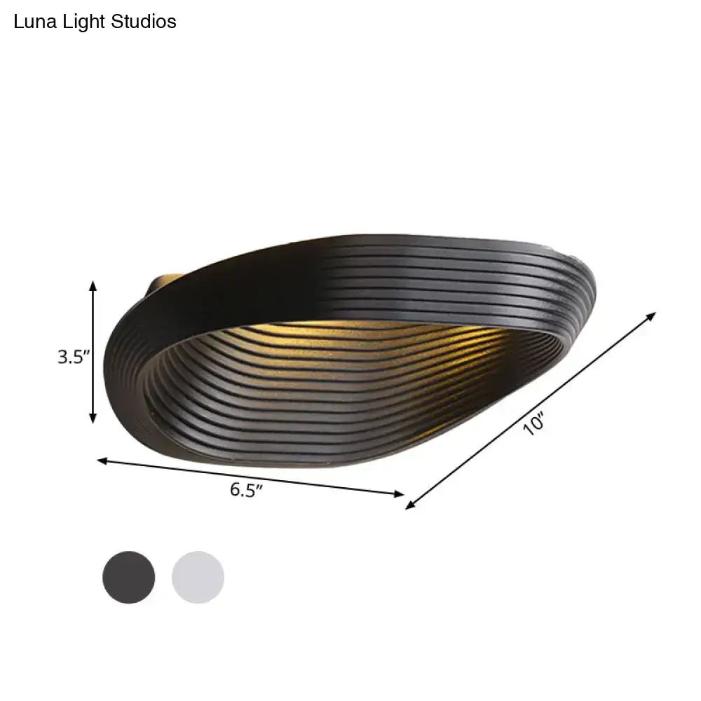 Black ribbed metal wall light with modern geometric design providing warm white light for bedroom use