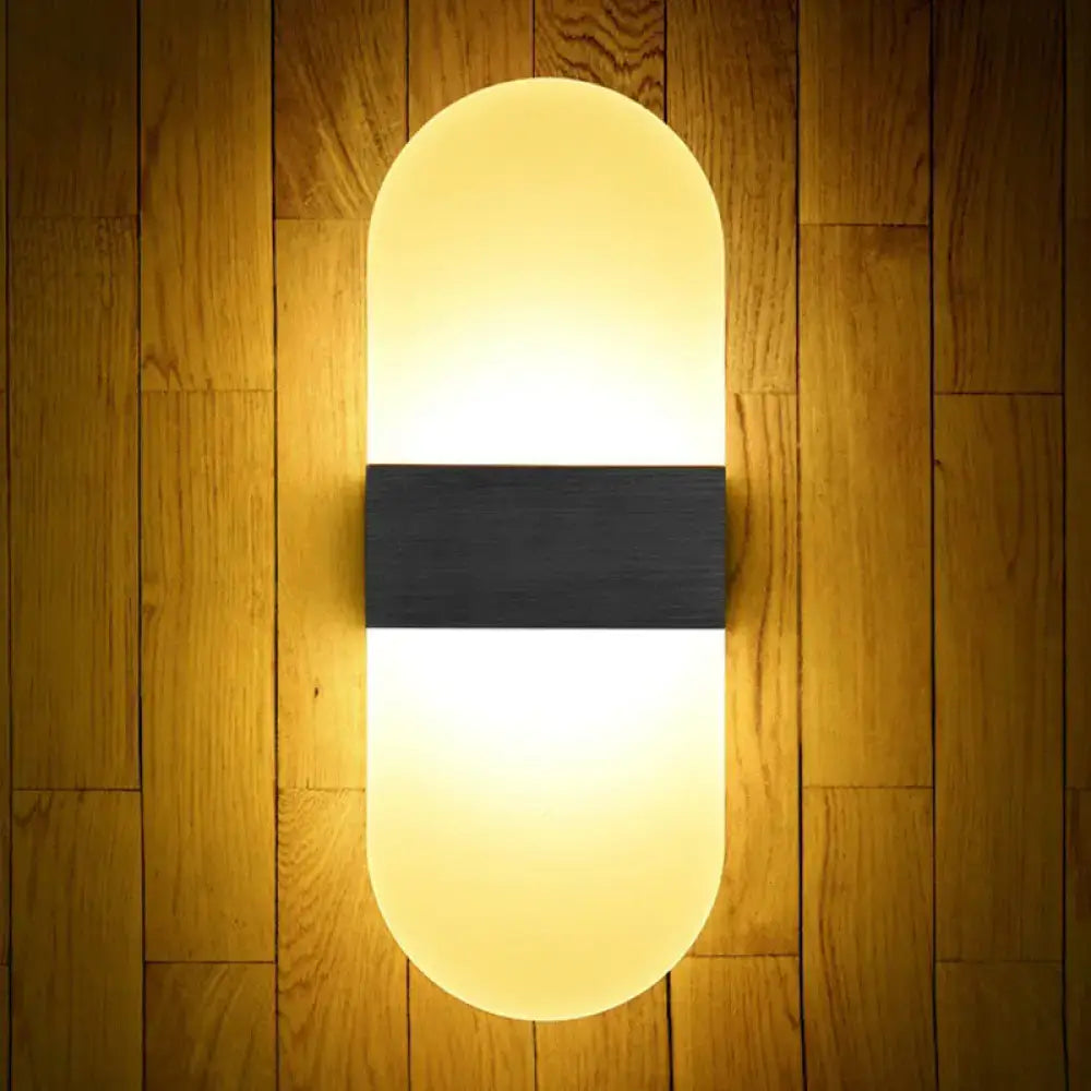 Modern geometric wood and acrylic wall sconce lamp with oval shape, warm yellow glow, and sleek black accent band wall lamp
