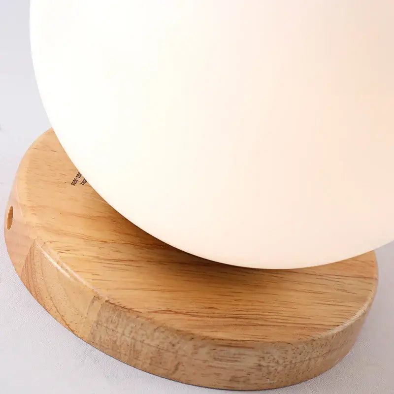Modern cream-colored glass ball led ceiling lamp with matte finish and wooden mount for bedroom decorbites glass ball design