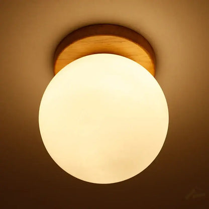 Warm-toned modern glass ball led ceiling lamp with frosted glass globe and natural wood mount for bedroom decorbites decor