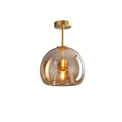 Modern glass ball led ceiling light with translucent amber glass globe and polished brass hardware for bedroom decorbites