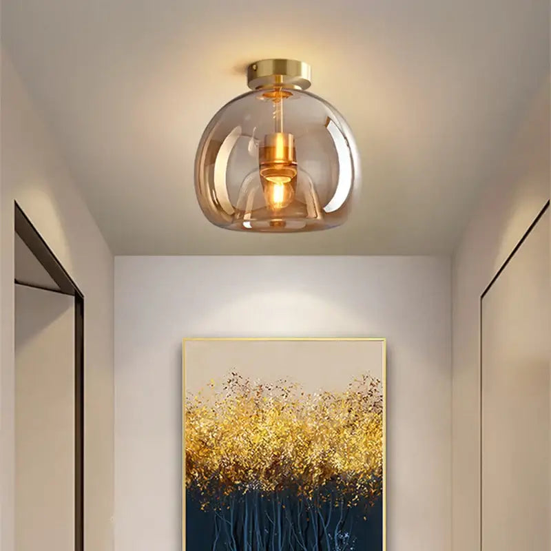 Modern ceiling light with a smoked glass ball led globe and gold-toned brass accents for bedroom decorbites lighting